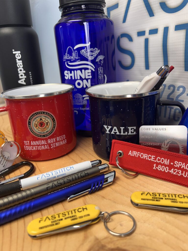Promotional items including mugs, pens, and water bottle.